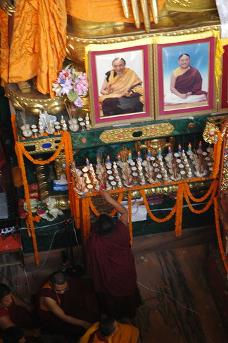 Photos of the late Chogye Trichen Rinpoche, and HH Sakya Trizin above elaborate shrine offerings and Earth Touching Buddha's fingers, on Bodhisattva Day, Tharlam Monastery of Tibetan Buddhism, Boudha, Kathmandu, Nepal by Wonderlane