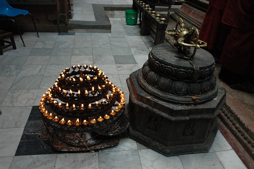 Mandala candle offering (4 tiered) with large dorje (vajra) on a pedestal, marble floor, monks robes, Mahabuddha Temple, also known as "temple of thousand buddhas", skikhar style buddhist temple, Kathmandu, Nepal by Wonderlane