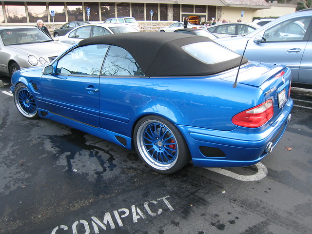 Fancy blue tricked out Mercedes convertible Taking up two compact car 