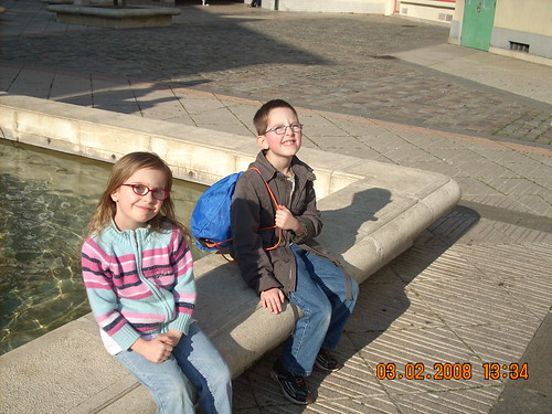 2 children sat next to a water fountain