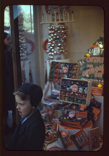 [Boy beside store window display of Christmas ornaments] (LOC)