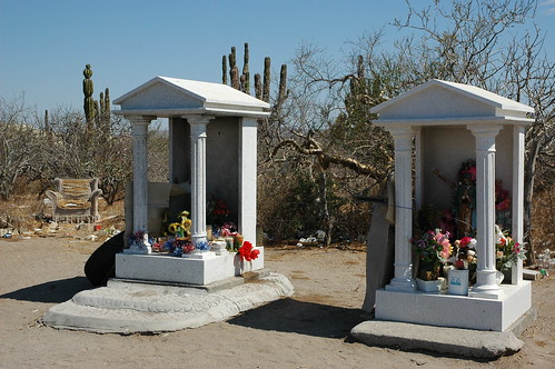 Roadside shrines in greek style, candles, statues, tire, trees, cactus, desert, abandoned armchair, Armchair philosophy; All the comforts of home, roadside worship area, worn out armchair in the desert, near La Paz, Baja California Sur, Mexico by Wonderlane
