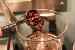 Dumping coffee beans into the grinder