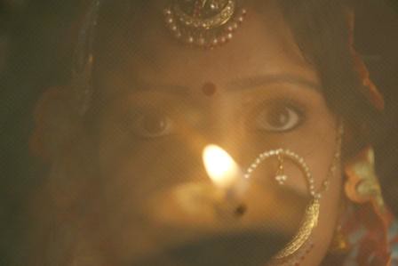 Lady seeing the moon through the sieve before breaking the fast on Karva Chauth