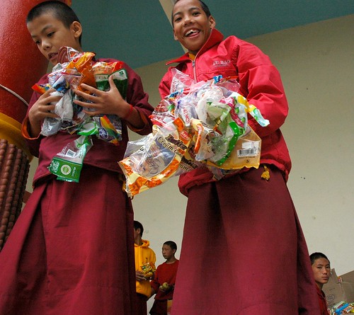 All eagerness - Packing up the offerings of candy and fruit, young monks, Tharlam Monastery of Tibetan Buddhism, Boudha, Kathmandu, Nepal by Wonderlane