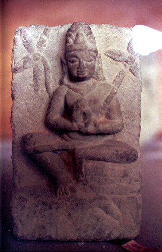 Stone statue of Lord Buddha as a meditator (wearing a mediation strap and a crown) seated with mudra, Kusinara, India by Wonderlane