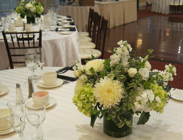Wedding centerpieces designed in cylinder vases with white and green toned