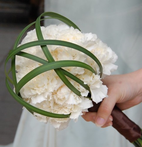 Brides maids bouquets created using white carnations and loops of lily grass