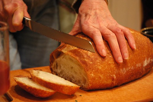 Cutting warm bread, at Q's party, Broadview Neighborhood, Seattle, Washington, USA