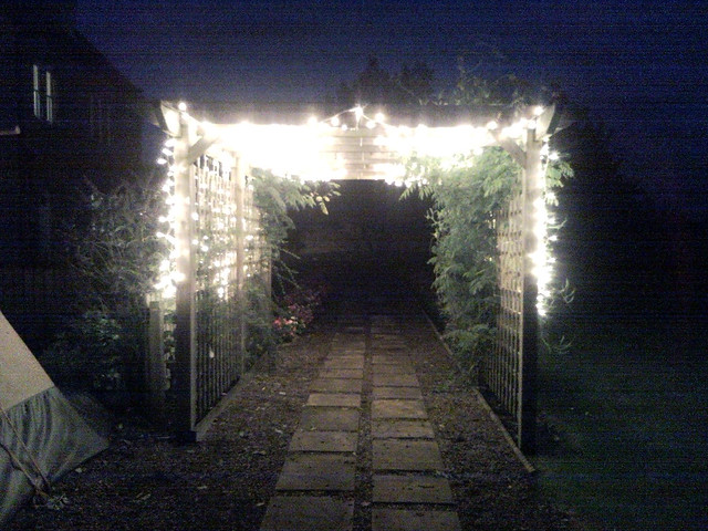 Pergola decorated for wedding with warm white lights