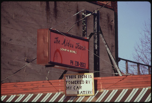 A Car Battery Operated This Neon Advertising Sign over a Business, During the Energy Crisis in December, 1973 12/1973