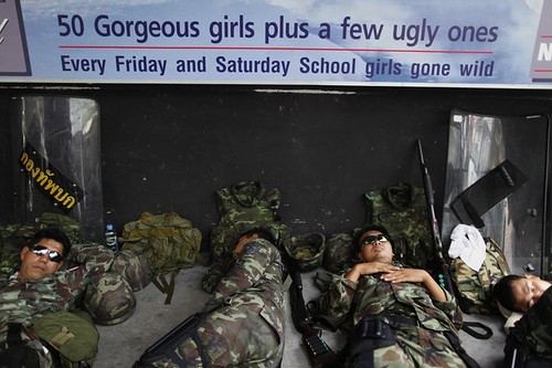 Thai soldiers doze outside a Bangkok go go bar.