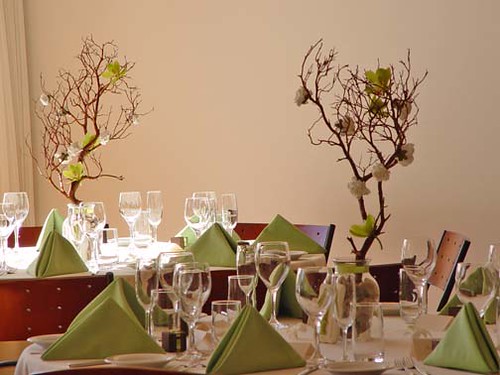 Centerpieces are made of manzanita branches with green cymbidium orchids and