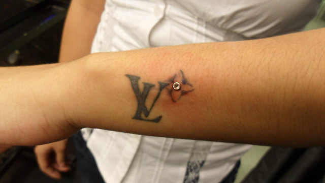 Girl Has tattoo of Louis Vuitton Symbol with Dermal Anchor Gem To top it off