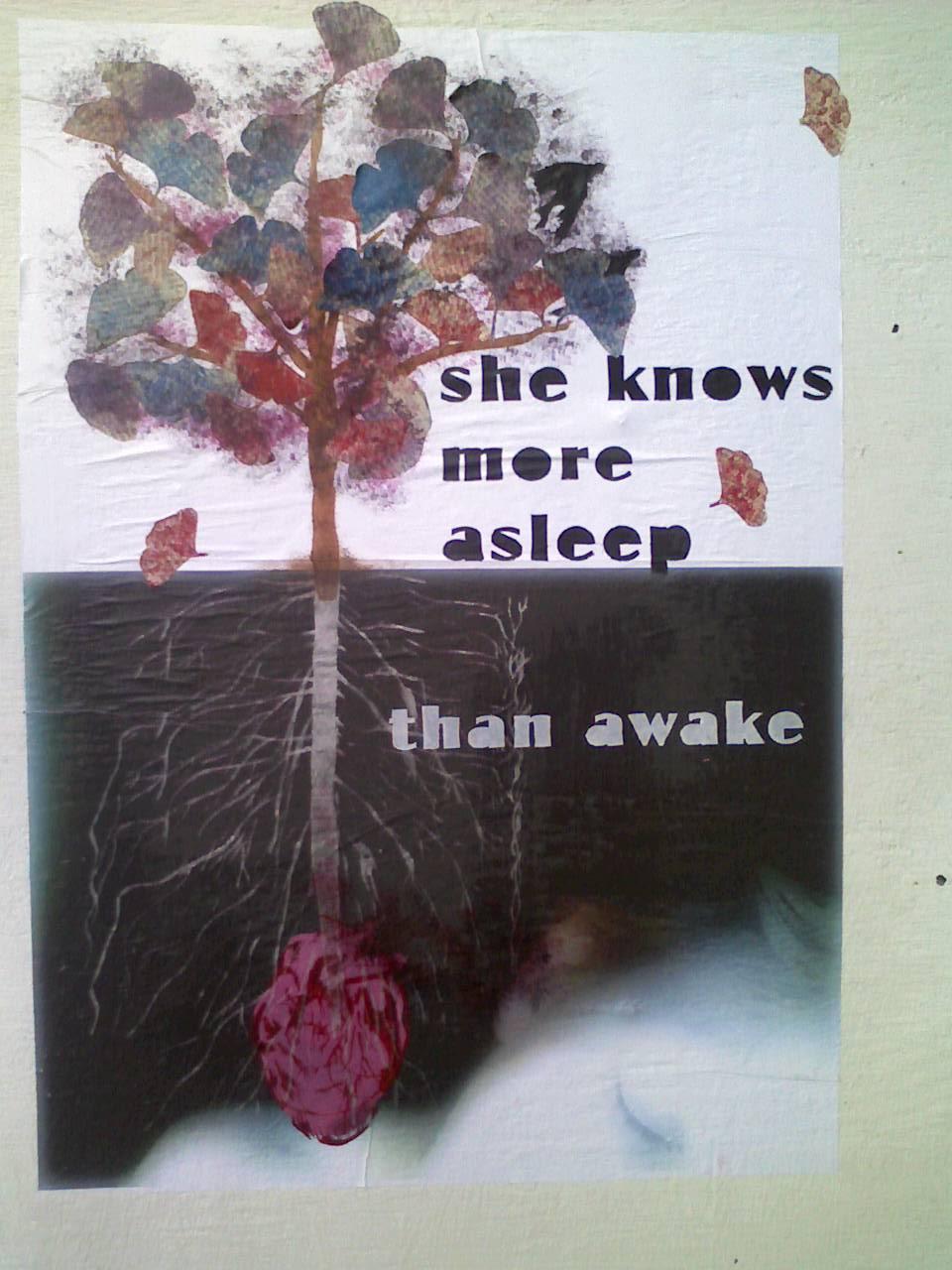 street art of a tree growing out of a heart next to the words, "she knows more asleep than awake"