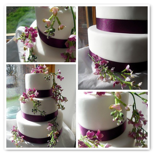 Plain white fondant covered 3 tier cake with deep purple satin ribbons