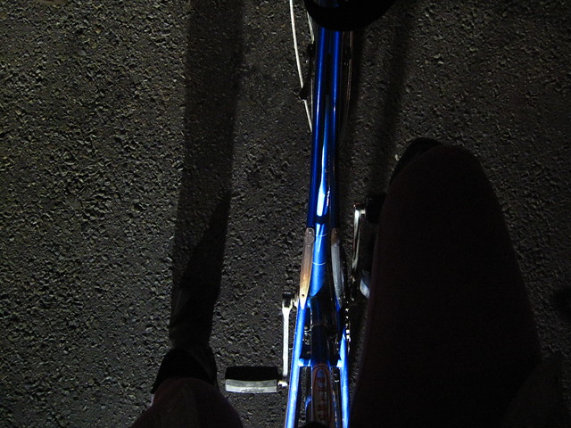 Red light, blue bike, black night.