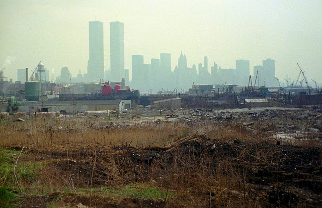 Jersey City. Industrial wasteland with the World Trade Center and Lower Manhattan in the distance. The old chromium plant on Henderson Street at left middle. 1975