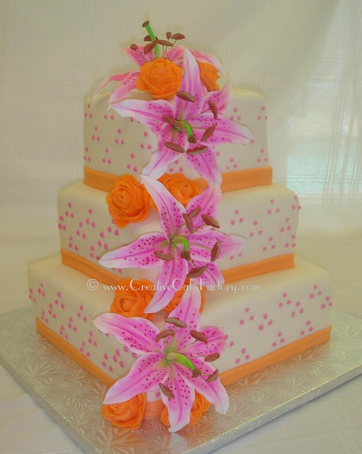 Each tier decorated with gumpaste stargazer lilies and orange roses