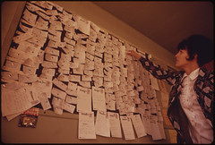 Woman looking at bulletin board full of paper notes