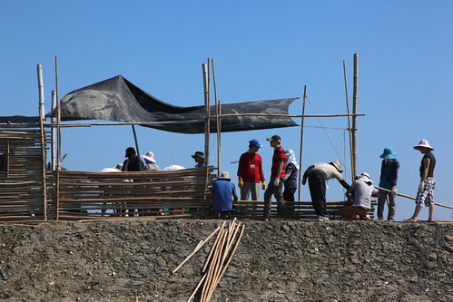 志工在師傅帶領下，使用竹子編列完成4公尺長的牆面。