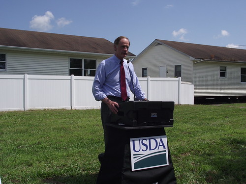 Senator Carper speaks at an event in Georgetown, Del., to highlight a USDA grant award that will help renovate the modular buildings behind him into a permanent home for Primeros Pasos (First Steps) early care and learning center. USDA photo.