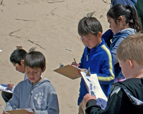 Siuslaw Elementary School students from Florence, Ore., record information about animal tracks found within the Oregon Dunes National Recreation Area during a field trip hosted by the Siuslaw National Forest field rangers, part of the Valuing People and Places program. (U.S. Forest Service photo)