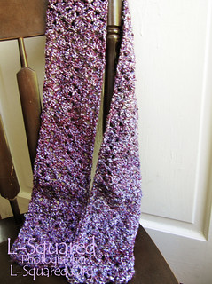 Completed scarf draped over the back of a wooden chair