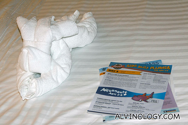 Towels folded into the shape of an elephant and the next day itinerary planner on our bed 
