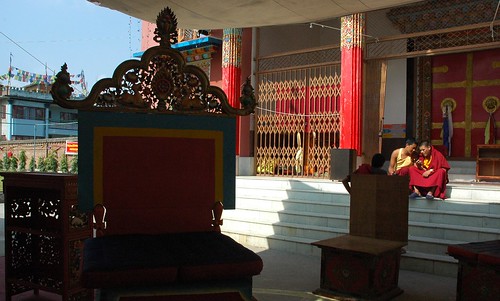 Monks chatting on the steps, lama's throne and table, side thrones, front doors of Tharlam Monastery, courtyard, shadow, gate, prayer flags, Sakya Lamdre, Boudha, Kathmandu, Nepal by Wonderlane