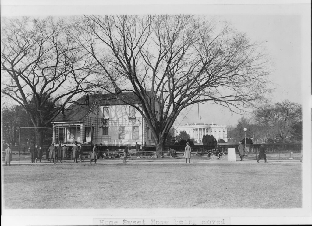 circa 1924: Moving a house in front of The White House in Washington, D.C.