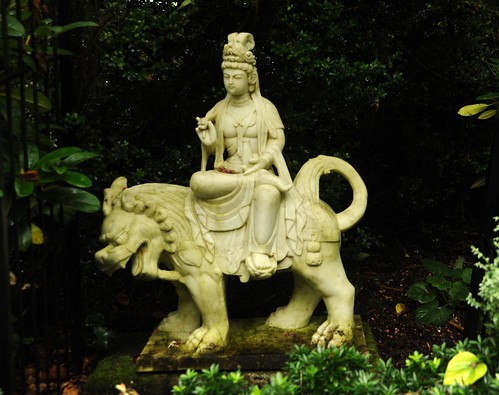 Bodhisattva Manjushri riding a lion,  tall headdress, robes, white carved marble,garden statue, private collection, Llandover by the Sound, Seattle, Washington, USA by Wonderlane