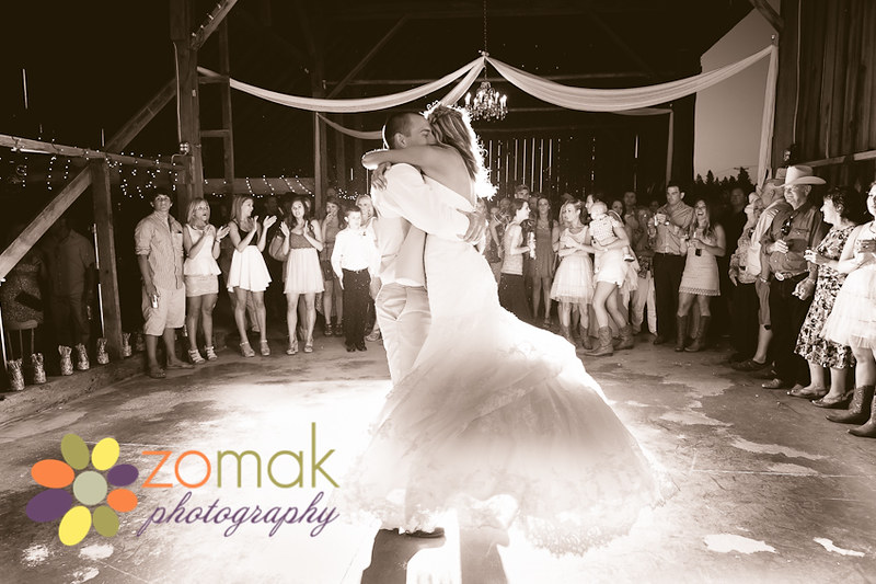 Groom swings bride around the dance floor at their country wedding.