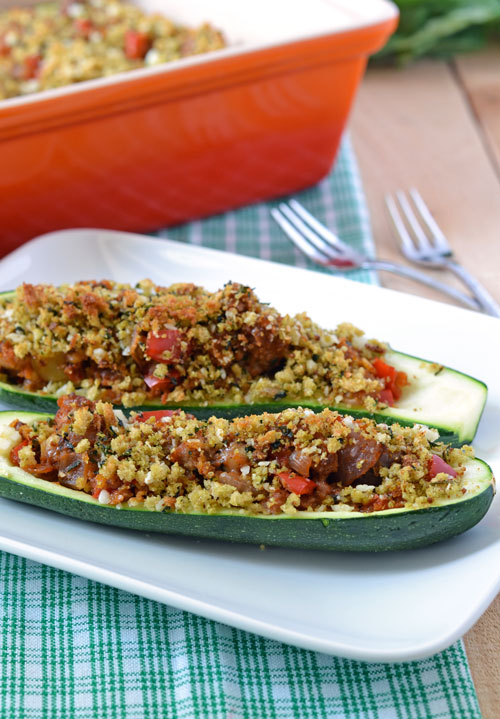Two stuffed zucchini halves on a white plate