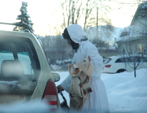 Priest wearing arctic winter whites carrying his vestments and bag, going to the Alaska Pioneer's Home to say Mass, snow, South Addition, Anchorage, Alaska, USA by Wonderlane