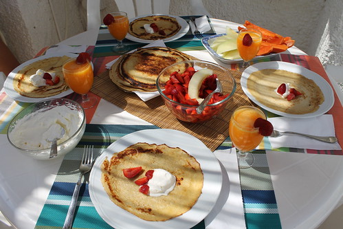 Crepes with whipped cream, sliced strawberries, freshly cut papaya and melon and freshly squeezed orange juice