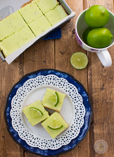 cut squares of key lime pie squares on plate topped with lime wedges