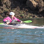 Deb in a slalom boat on the Swellies wave - By Sea Kayaking Anglesey