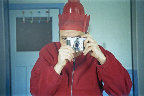reflected self-portrait with Kodak Retinette I camera and compound red hat by pho-Tony