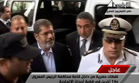 Deposed Egyptian President Mohamed Morsi being brought into court at the police academy. Morsi was overthrown by the military on July 3, 2013. by Pan-African News Wire File Photos