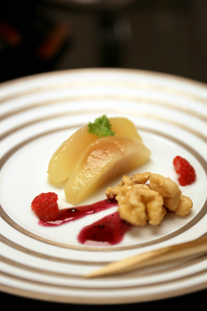 Dessert of stewed pear in syrup, walnuts and raspberry