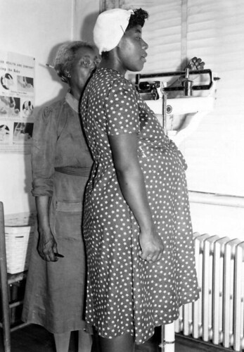 Midwife weighing pregnant woman