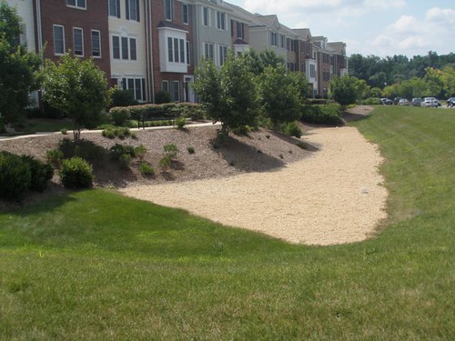 Image of a sand filter next to a row of townhomes. A sand filter is a stormwater management best practice.