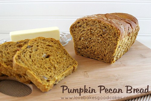Pumpkin Pecan Bread sliced on cutting board with a stick of butter.