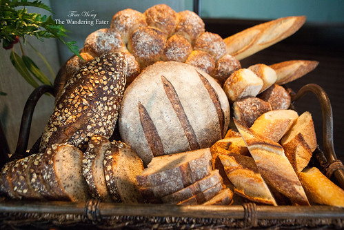 Bountiful bread basket of Rosemary focaccia, baguette, and sliced dark rye sourdough