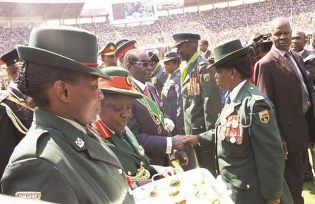 President Mugabe congratulates Major Julian Chaneka while Colonel Zvanyadza Machinjili and Sergeant Dube Chimusasa look on during the 33rd Zimbabwe Defence Forces Day. by Pan-African News Wire File Photos