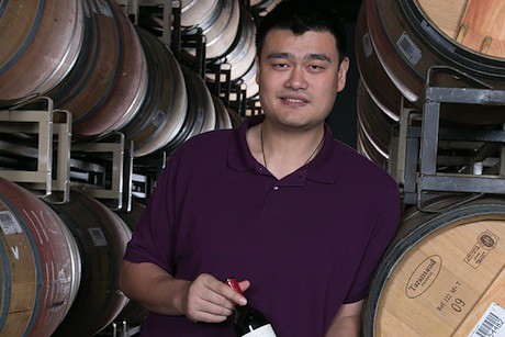 August 2013, 2013 - Yao Ming stands in front of wine barrels at his winery