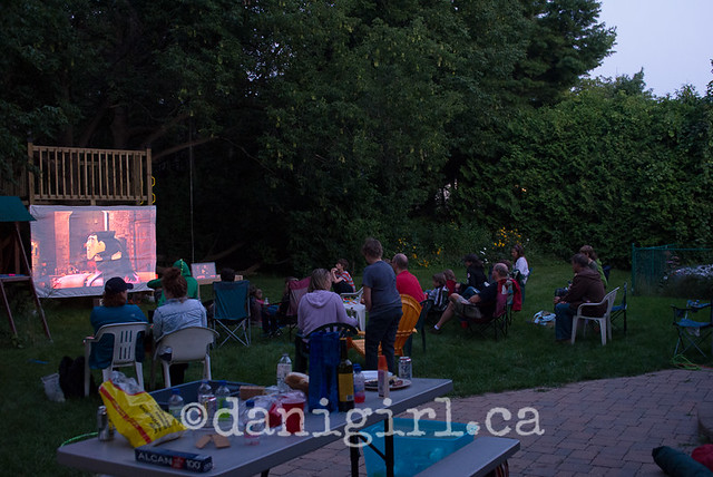 outdoor photo of families watching a movie in backyard
