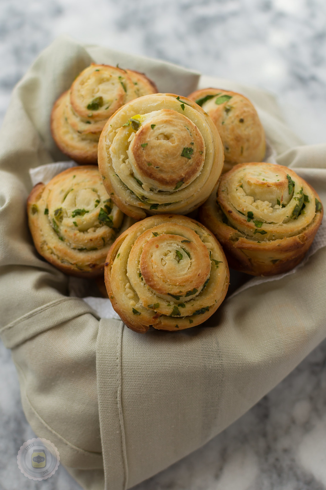 jalapeno parmesan swirl bread rolls in towel lined basket showcasing swirls