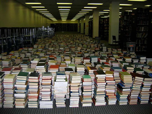 Image of stacked books covering entire floor of library